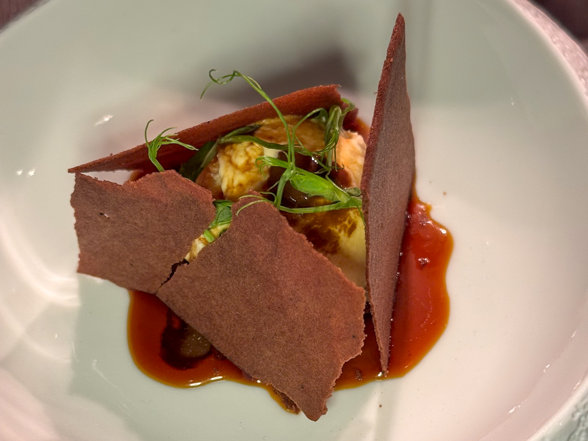 Dolceamara Bologna: gelato salato, bucce arrostite, rosmarino, caramello ai funghi e soia, aglio nero fermentato, cacao amaro.